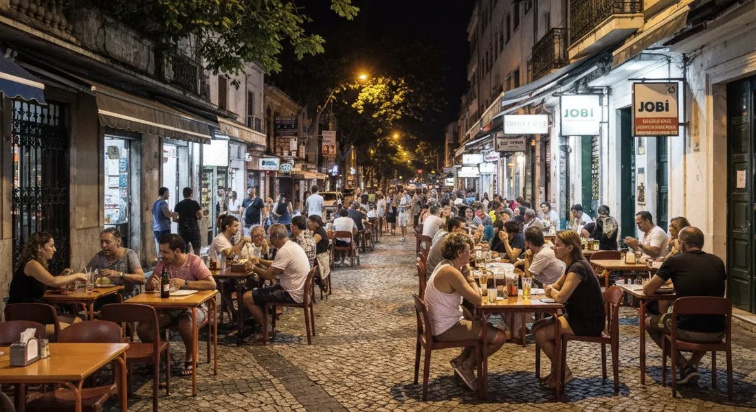 Jobi en Avenida Ataulfo de Paiva de noche, mesas en la acera abarrotadas con vasos de chopp frío, platos de boteco y vecinos charlando bajo las farolas